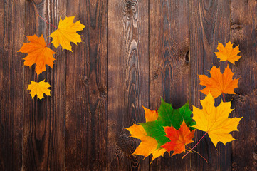 frame of autumn maple leaves on a wooden background. Design and space for text