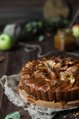 Apple pie with salted caramel on a wooden background