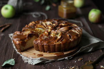 Apple pie with salted caramel on a wooden background