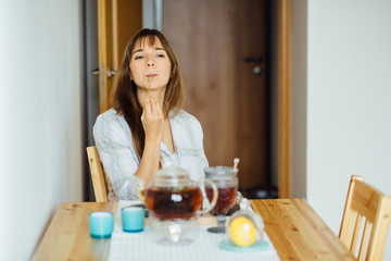 Beautiful young woman having breakfast in kitchen.