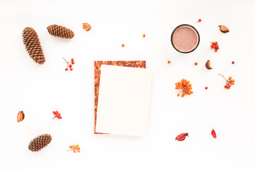 Autumn workplace. Notebook, pine cone, cup of coffee, marshmallow on white background. Flat lay, top view. Autumn background