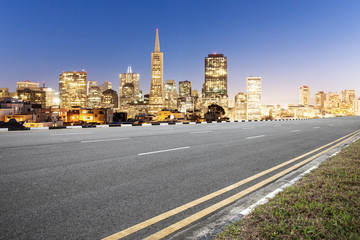 Obraz premium empty asphalt road and cityscape of modern city in blue sky at dawn