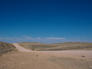 Hot beautiful day on adventure road trip through desert rock mountain landscape route to emptiness with blue sky background
