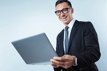 Low angle shot of radiant businessman working on laptop