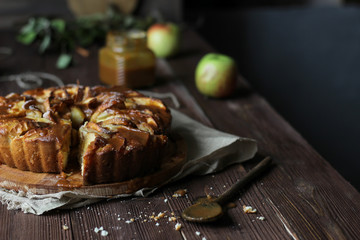 Apple pie with salted caramel on a wooden background