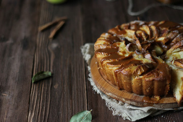 Apple pie with salted caramel on a wooden background