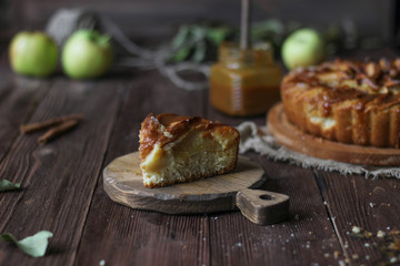 Apple pie with salted caramel on a wooden background