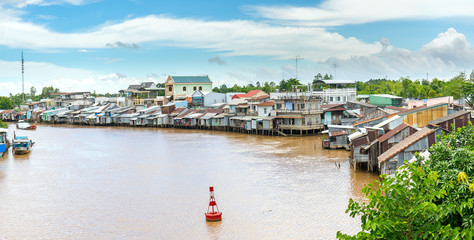 Can Tho, Vietnam - August 25th, 2017: Ships cross the confluence of riverside riverside villages...