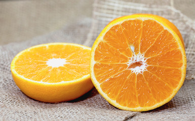 Orange, half of orange,with oranges on the wooden table on the sack background