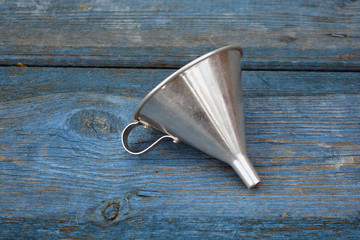 Vintage metal funnel with handle on old wooden  garden table - obrazy, fototapety, plakaty