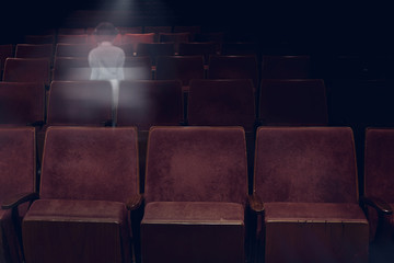 transparent ghost little girl appears between vintage seat in movie theater, horror film, halloween...