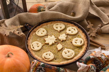 Pumpkin Pie decorated for Halloween. Fresh round bright orange homemade pumpkin pie on table.Thanksgiving background, top view.