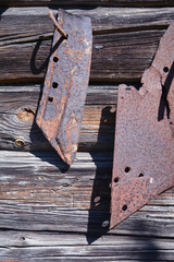 Old rusty plow blade  on gray wooden barn wall