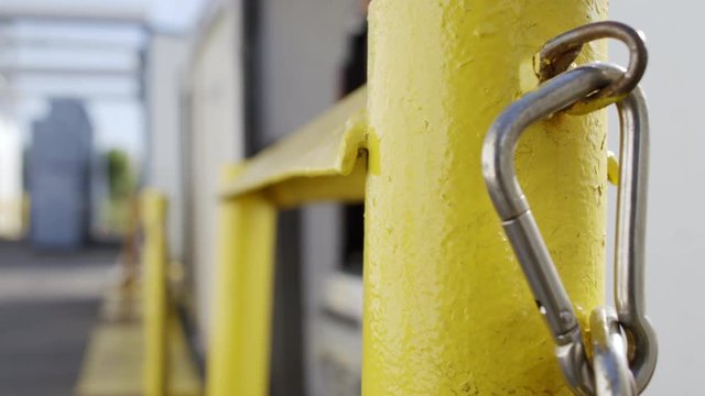Focus on bright yellow safety post as forklift driver loads a truck trailer in background at loading dock. Real-time 4K