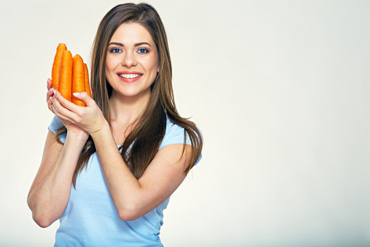 Smiling woman holding bundle of carrot.