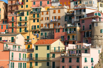 Fototapeta na wymiar Picturesque view of the colorful houses along the main street in a sunny day in Manarola. Manarola is one of the five famous villages in Cinque Terre (Five lands) National Park. Liguria, Italy, Europe