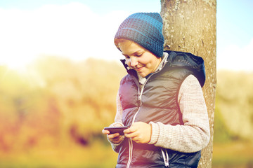 happy boy playing game on smartphone outdoors