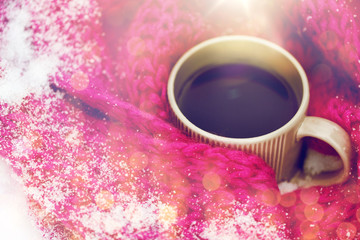 Obraz na płótnie Canvas close up of tea or coffee and winter scarf in snow