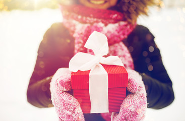 close up of woman with christmas gift outdoors