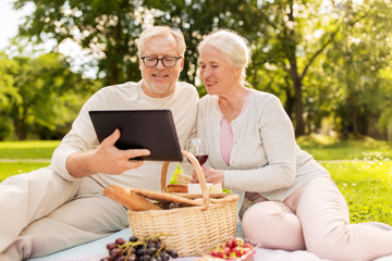 happy senior couple having picnic at summer park