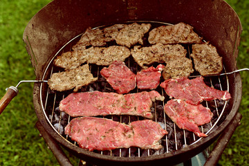 beef steak on barbecue grill in the garden for outdoor picnic.