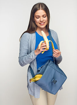 Smiling woman holdin fabric lunch bag.