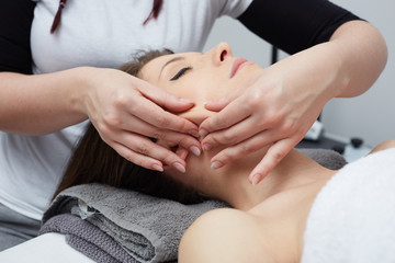 Fototapeta na wymiar Female Enjoying Relaxing Back Massage In Cosmetology Spa Center