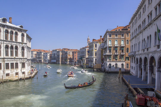 View of the Grand Canal with boats and colorful facades of old medieval houses from the Rialto Bridge in Venice, Italy. Venice is a popular tourist destination of Europe.