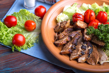 Pieces of roasted meat with tomatoes