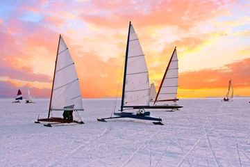 Photo sur Aluminium Sports dhiver Ice sailing on the Gouwzee in the countryside from the Netherlands at sunset