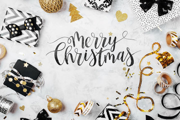 Merry Christmas Card with black and gold Christmas gifts, bows and decorations. Flat lay, top view.