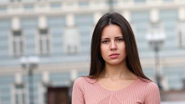 Silence sign. Young brunette woman in dress, street outdoors
