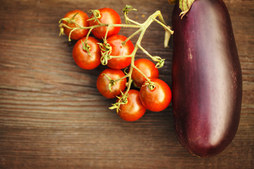 Fresh eggplant with tomato on a wooden table. Autumn concept.