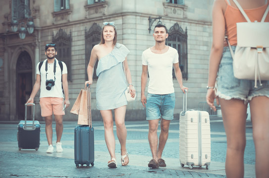 Cheerful man and woman in shorts with luggage