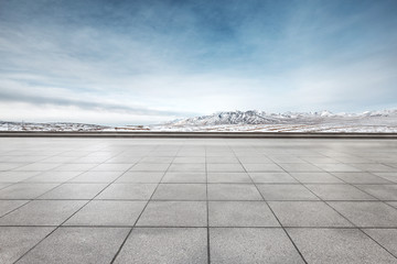 empty floor with white snow mountain in blue sky