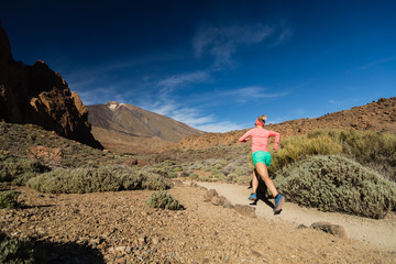 Fototapeta premium Trail running woman in mountains on sunny day