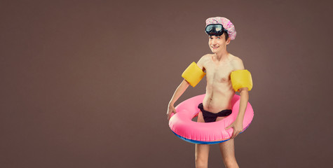 Funny cheerful thin man in a bathing suit with an inflatable cir