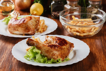 Roasted chicken legs with french fries and lettuce