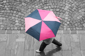 femme traversant une place pavés avec un parapluie