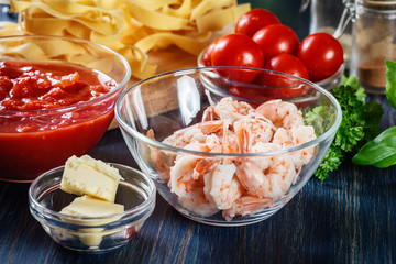 Ingredients ready for preparing pappardelle pasta with shrimp, tomatoes and herbs
