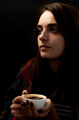 a young beautiful girl with hips on her shoulders holding a cup of coffee thoughtfully looking sideways, a cute portrait