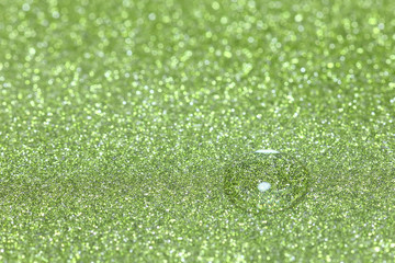 Water drop on sparkling green