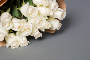 Natural white roses on the grey background with copy space.