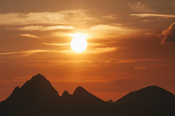 The sun sets over the mountain peaks