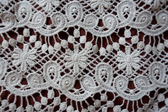 Perforated white lace with floral pattern from above