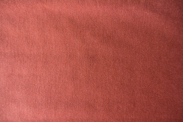 Plain coral colored jersey fabric from above