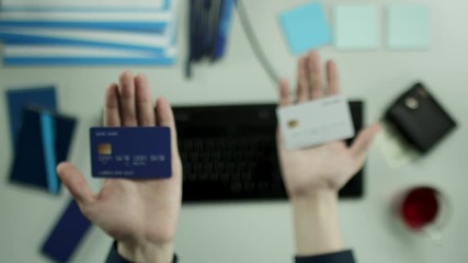 Top view of man comparing credit cards