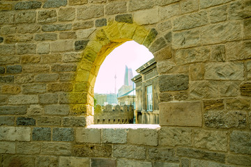 Ancient stone window with castle and sky background