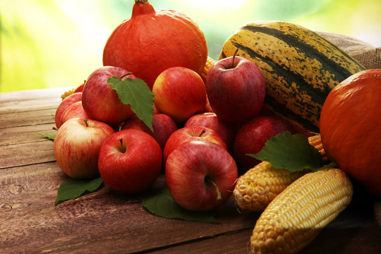 Thanksgiving - pumpkin, apples, and maize on wooden background