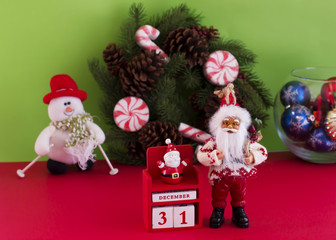 Santa Claus and New Year's calendar on December 31 on the background of a spruce wreath, a snowman and Christmas balls. Green and red background
